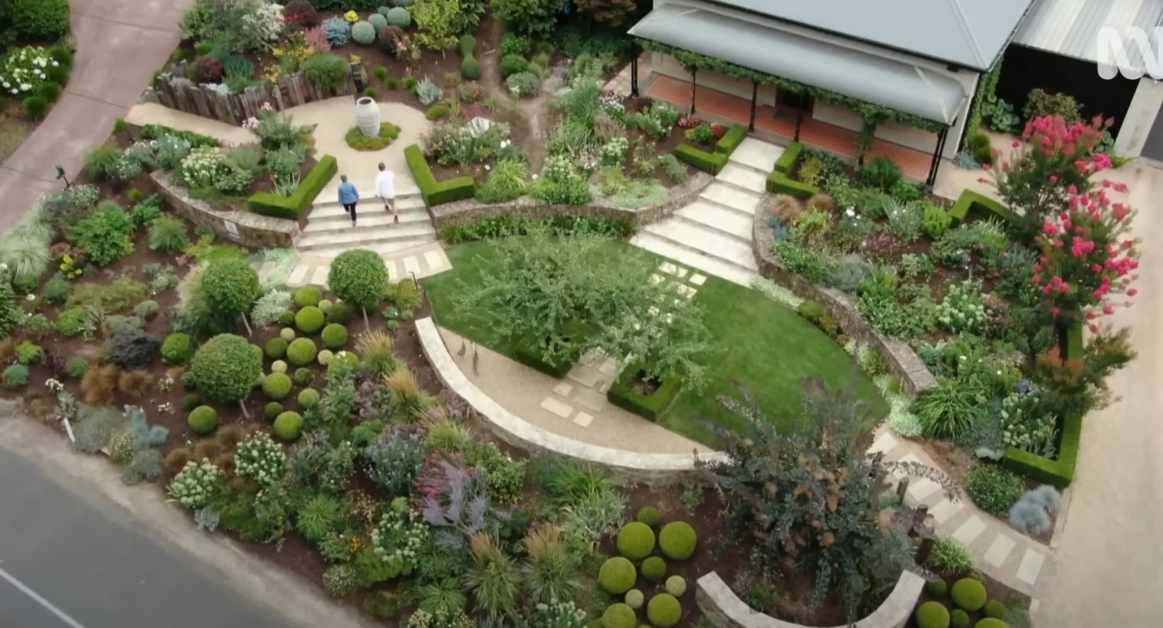 Award-winning landscape design featuring curved walkways and structured planting Aerial view of professionally designed landscape with curved pathways and geometric garden beds